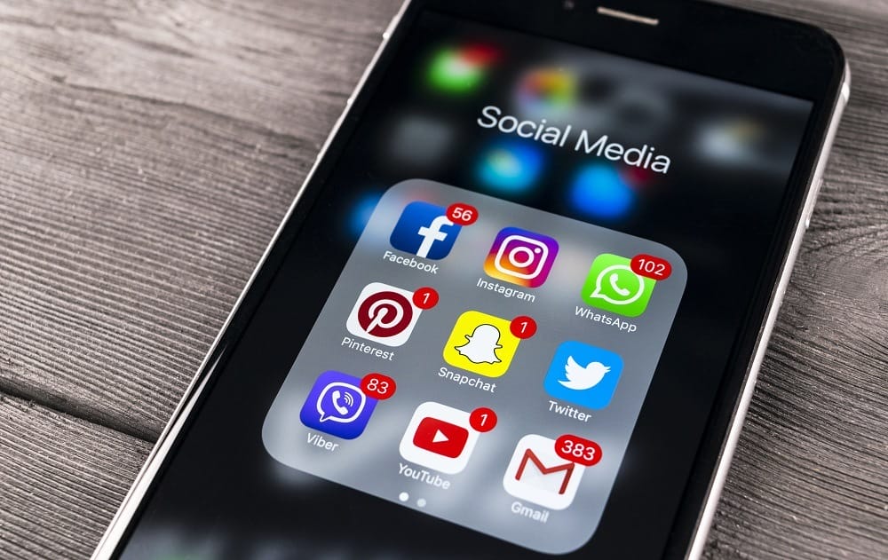 iphone on table with app push notifications visible for social media apps